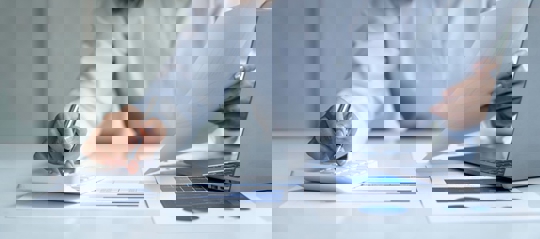 working on laptop, calculator and paperwork